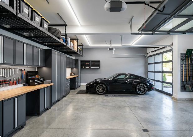 Organized garage with cabinets, workbench, and car