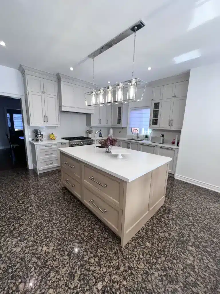 Kitchen storage ideas in an Ontario home: a wood-front island with deep drawer storage set against greige shaker perimeter cabinetry.