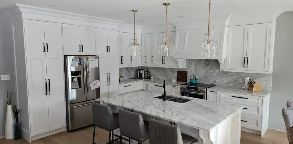 Custom kitchen cabinets in an Ontario home: a floor-to-ceiling white shaker cabinet run, marble-look counters and backsplash, and a seated island.