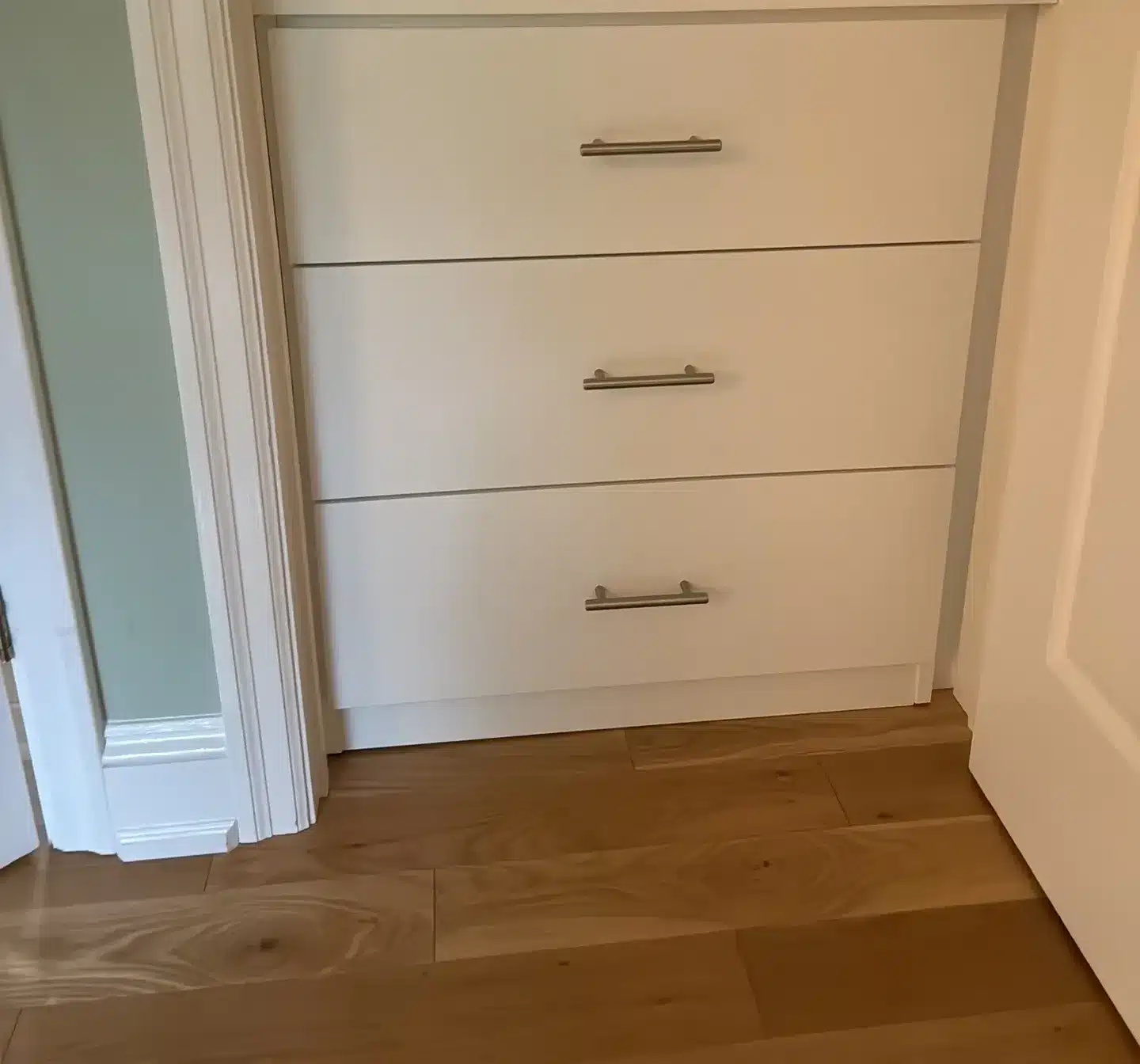 White three-drawer dresser built into a bedroom closet in Aurora