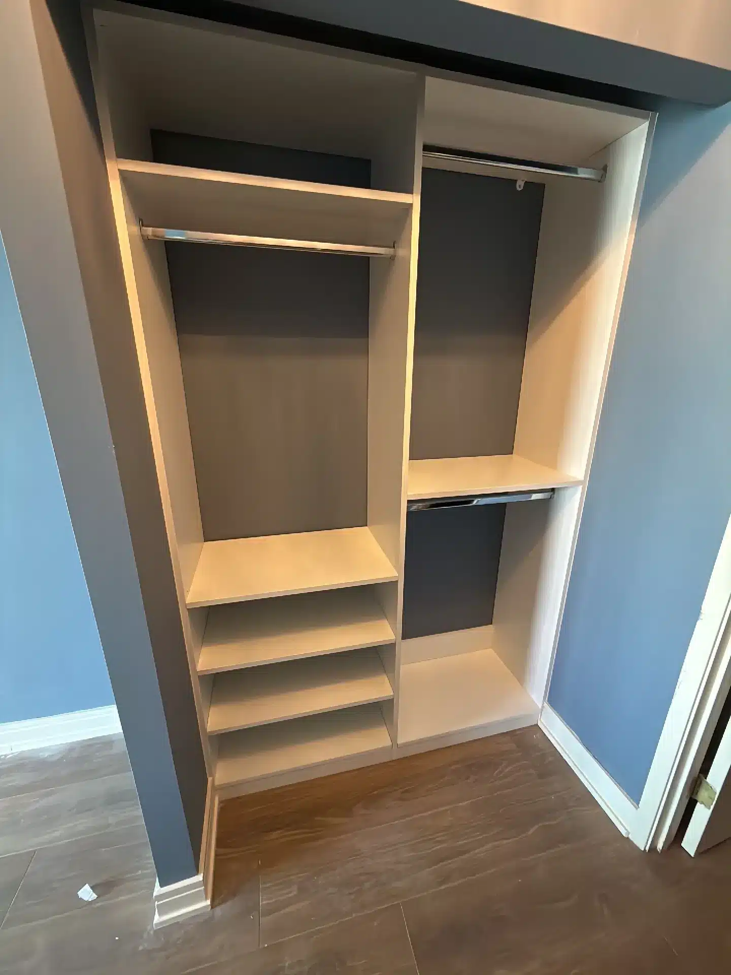 Reach-in closet in Barrie in a light woodgrain finish with dark back panels, double hanging and a stack of shelves