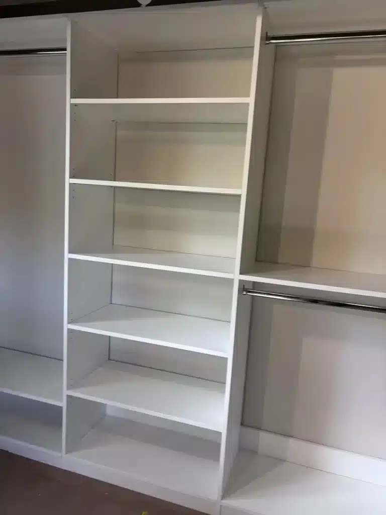 Three-section white reach-in closet in Midland, a shelf tower in the middle and double hanging either side