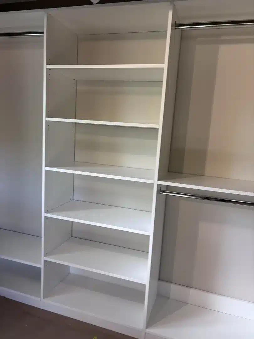 Three-section white reach-in closet in Midland, a shelf tower in the middle and double hanging either side